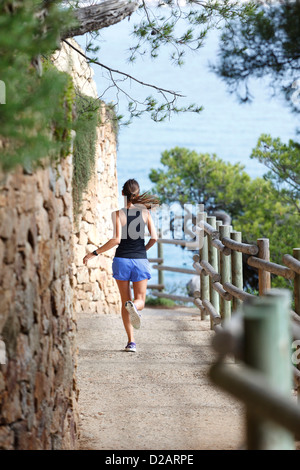 Woman running on dirt path Banque D'Images