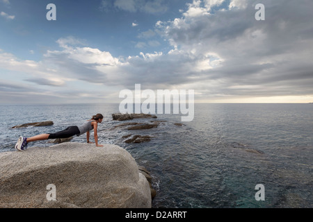 Femme sur rocher surplombant Ocean Banque D'Images