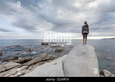 Femme sur rocher surplombant Ocean Banque D'Images