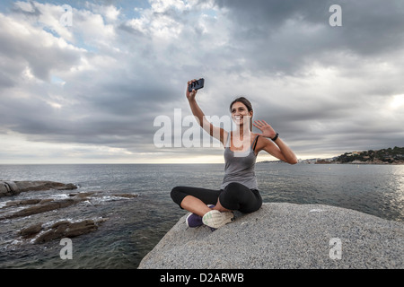 Woman taking photo d'elle-même à l'extérieur Banque D'Images