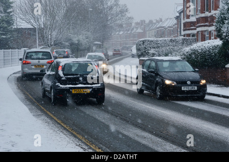 Automobile tourisme lentement le long d'une route couverte de neige en hiver Banque D'Images