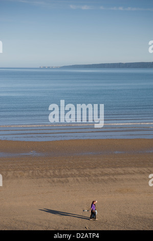 Couple strolling sur plage de sable tranquille sur soirée d'été ensoleillé calme par mer plate sous ciel bleu - South Bay, Scarborough, Yorkshire Coast, England, UK. Banque D'Images