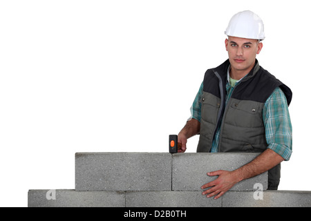 Charpentier pose par mur en béton isolé sur blanc Banque D'Images