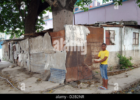 La Havane, Cuba, un jeune homme se tient sur un coin de rue en face du slogan Viva Fidel Banque D'Images