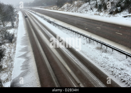 Une voiture se déplace le long d'une autoroute couverte de neige dans le Shropshire, Angleterre Banque D'Images