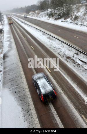 Une voiture se déplace le long d'une autoroute couverte de neige dans le Shropshire, Angleterre Banque D'Images