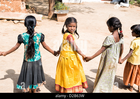 Les enfants du village indien dans une ligne holding hands playing games. L'Andhra Pradesh, Inde Banque D'Images