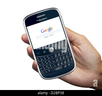 Une personne titulaire d'un téléphone intelligent Blackberry 9000 isolé en fond blanc avec site web de Google Banque D'Images