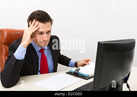 L'homme d'affaires concentré dans son bureau avec la main droite sur sa tête. Banque D'Images