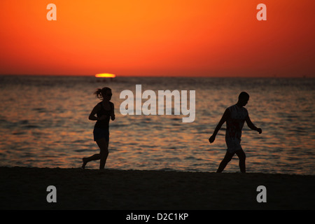 Les coureurs et marcheurs au lever du soleil la célèbre Sydney Bondi Beach sur une journée de canicule. Banque D'Images