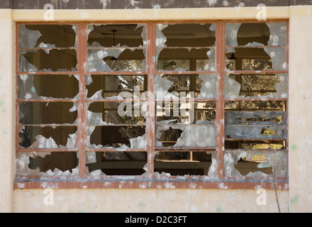 Une fenêtre avec le verre éclaté de ce qui est dans un bâtiment abandonné sur le Fort Ord, une base militaire. Banque D'Images