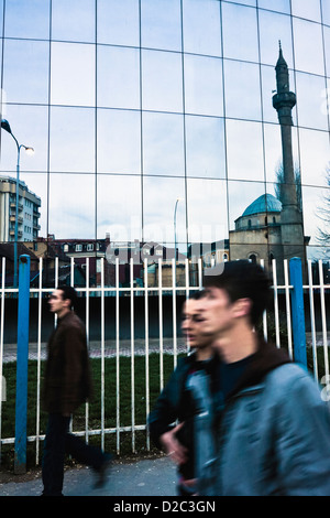 Les gens qui marchent par la mosquée de Fatih réfléchi à nouveau bâtiment miroir Pristina Kosovo Banque D'Images