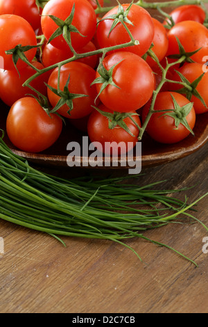 Tomates cerises fraîches sur plaque de bois Banque D'Images