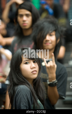 Les adolescents en attente de l'ouverture d'un club d'assister à un concert de rock, à Bangkok, Thaïlande Banque D'Images