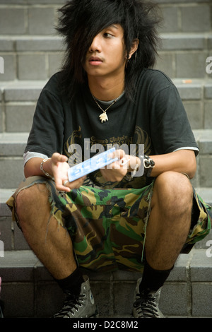 Les adolescents en attente de l'ouverture d'un club d'assister à un concert de rock, à Bangkok, Thaïlande Banque D'Images