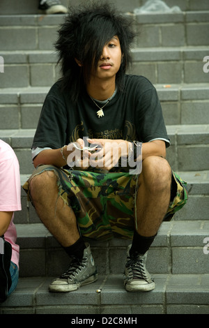 Les adolescents en attente de l'ouverture d'un club d'assister à un concert de rock, à Bangkok, Thaïlande Banque D'Images