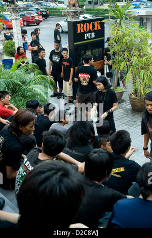 Les adolescents en attente de l'ouverture d'un club d'assister à un concert de rock, à Bangkok, Thaïlande Banque D'Images