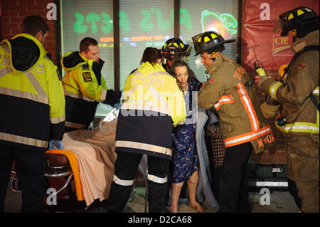 Toronto, le 20 Jan 2013 PEUT, - les pompiers et Toronto EMS évaluer un résident après avoir été sauvé d'un incendie. Les ambulanciers traités une femme âgée après un 2-alarme incendie au 3266, rue Yonge, au nord du Saint-Laurent. Banque D'Images