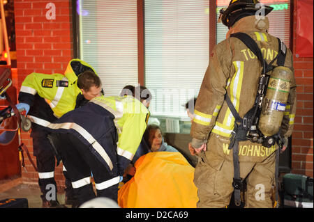Toronto, le 20 Jan 2013 PEUT, - les pompiers et Toronto EMS évaluer un résident après avoir été sauvé d'un incendie. Les ambulanciers traités une femme âgée après un 2-alarme incendie au 3266, rue Yonge, au nord du Saint-Laurent. Banque D'Images