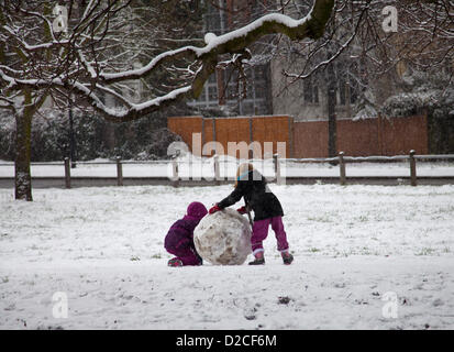 20 janvier 2013 13.18 H - La neige tombe sur Clapham Common à Clapham, Londres, Royaume-Uni. deux jeunes enfants rouler une boule de neige Banque D'Images