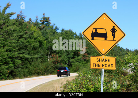 Un partage de la route avec les vélos jaune Attention à côté d'une autoroute Banque D'Images