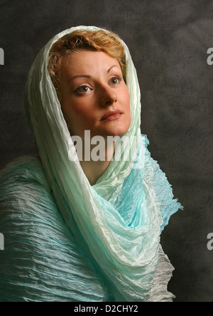 La belle fille dans une écharpe bleue en studio Banque D'Images