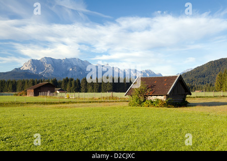 Huttes de bois sur les prairies alpines dans la lumière du soleil du matin, Allemagne Banque D'Images