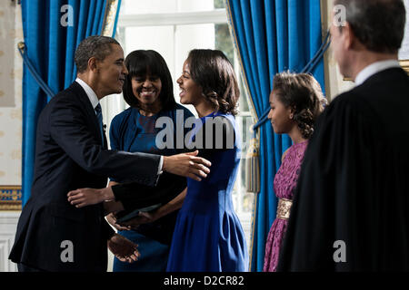 Le président des États-Unis Barack Obama (L) embrasse sa fille Malia Obama (C) en tant que Première Dame Michelle Obama (2L), fille Sasha Obama (2) et US en chef de la Cour suprême, John Roberts Jr. regarder après une prestation de serment pour un second mandat en tant que président dans la salle bleue de la Maison Blanche le 20 janvier 2013 à Washington, DC. Obama a prêté serment pour son deuxième mandat en tant que 44e président des États-Unis au cours de la 57e Cérémonie d'investiture mais aussi de participer à une cérémonie de prestation de serment lundi. .Crédit : Brendan Smialowski / Piscine via CNP Banque D'Images