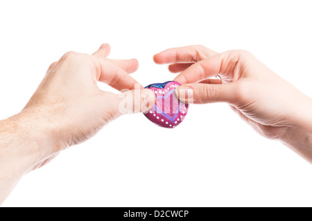 Peint rose en forme de coeur fait main dans les mains de pierre de young man and woman isolated on white Banque D'Images