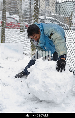 La neige pour faire rouler l'homme snowman, Surrey, Royaume-Uni. Banque D'Images