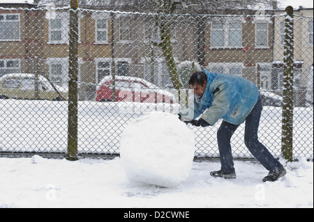 La neige pour faire rouler l'homme snowman, Surrey, Royaume-Uni. Banque D'Images