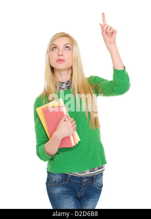 Happy student girl with books pointant vers le haut sur copy space Banque D'Images