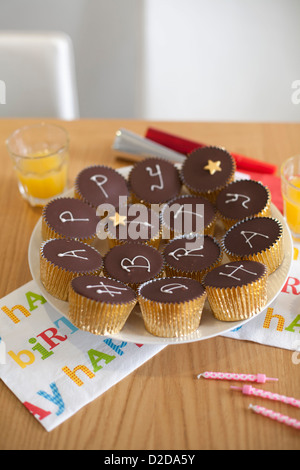 Une assiette de cupcakes avec Joyeux Anniversaire écrit sur eux Banque D'Images