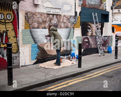 Artistes - Bom K et Liliwenn - groupe de travail sur l'art de rue dans le Hanbury Street, à côté de Brick Lane, London Banque D'Images