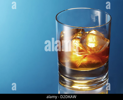 Verre de whisky sur un fond bleu. Banque D'Images