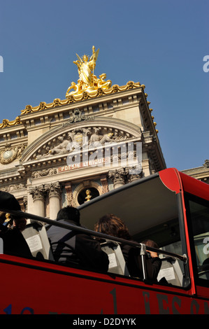 Les touristes sur le pont supérieur d'un bus panoramique passant l'Opéra de Paris France Banque D'Images