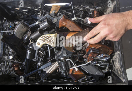 21 janvier 2013 - Los Angeles, Californie, États-Unis - un shérif du comté de Los Angeles met un pistolet sous-récupérés dans un panier au cours d'une ''cadeaux'' des armes à feu programme change lundi. Les gens peuvent se transformer en une arme à feu et de recevoir une carte-cadeau d'une valeur de 200 $ pour une arme d'assaut, 100 $ pour une arme de poing, et de 50 $ pour un fusil de chasse. (Crédit Image : © Chiu/ZUMAPRESS.com) Ringo Banque D'Images