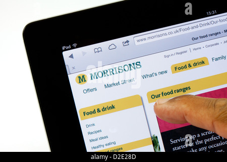 Une personne shopping sur internet à la supermarché Morrisons, site web sur un iPad, UK Banque D'Images