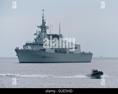 Un pneumatique à coque rigide (RHIB) passe devant la frégate de la Marine royale canadienne NCSM Toronto (FFH 333). Banque D'Images