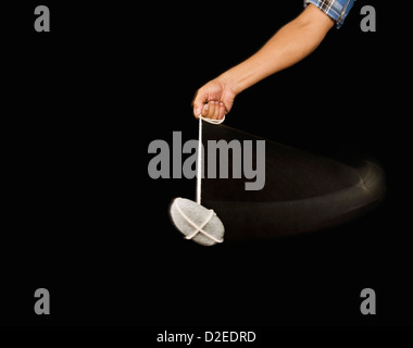 Close-up of a person's hand balancer un pendule en pierre Banque D'Images