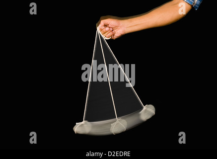 Close-up of a person's hand balancer un pendule en pierre Banque D'Images