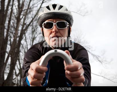Un gros plan d'une femme lunettes cycliste avec son vélo de triathlon d'équitation. Banque D'Images