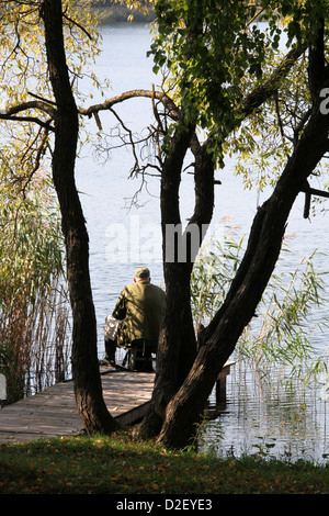 Un pêcheur au bord du lac dans la station balnéaire de Lituanie Trakai Banque D'Images