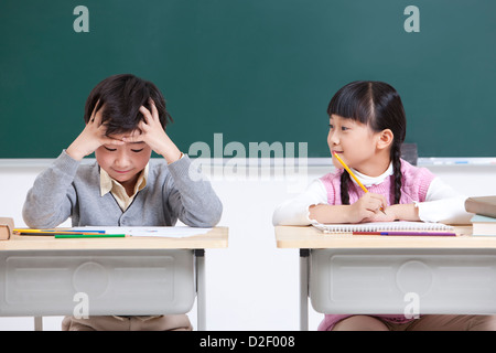 Les élèves font leurs devoirs dans la jolie salle de classe Banque D'Images