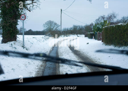 La vue depuis l'intérieur d'une voiture de la neige a couvert les routes rurales à Norfolk, Royaume-Uni. Une limite de vitesse de 30 mi/h signe peut également être vu dans l'image. Banque D'Images