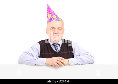 Gentleman wearing party hat and posing derrière un panneau blanc isolé sur fond blanc Banque D'Images