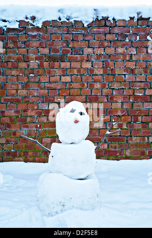 Le SNOWMAN contrastant contre un mur de briques Banque D'Images