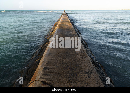 L'homme à l'extrémité d'une jetée en béton, la plage de Waikiki, Oahu, Honolulu, Hawaii, USA Banque D'Images