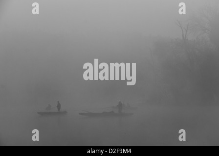 Silhouette de People Rowing Boat - Port d'un trou perdu) d'Oxbow (Tisza en noir et blanc au lever du soleil avec les pêcheurs Banque D'Images