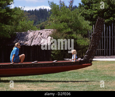 La mère et l'enfant assis dans la pirogue de guerre Maori Whakarewarewa Village Thermal à vie, Rotorua, Bay of Plenty, Nouvelle-Zélande Région Banque D'Images